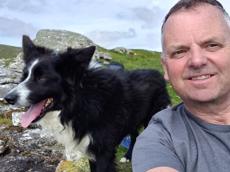 A man taking a selfie with his dog.